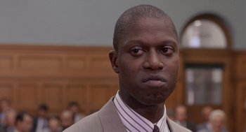 Movie still from “Striking Distance” (1993), directed by Rowdy Herrington – A person wearing a suit and tie; Close Up shot, Low angle