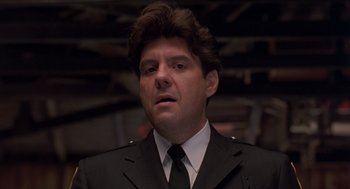 Movie still from “Striking Distance” (1993), directed by Rowdy Herrington – A person wearing a suit and tie; Close Up shot, Low angle