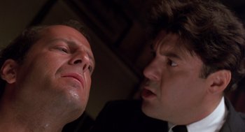 Movie still from “Striking Distance” (1993), directed by Rowdy Herrington – Two men in business suits looking at each other; Close Up shot, Low angle