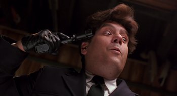 Movie still from “Striking Distance” (1993), directed by Rowdy Herrington – A man in a suit and tie holding a hairdryer; Close Up shot, Low angle