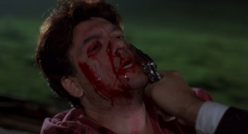Movie still from “Striking Distance” (1993), directed by Rowdy Herrington – A man with blood all over his face is holding a gun; Close Up shot, Low angle