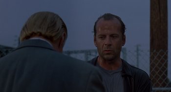 Movie still from “Striking Distance” (1993), directed by Rowdy Herrington – A man is looking into a mirror while another man looks at him; Close Up shot, Over the shoulder angle