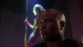Movie still from “Striptease” (1996), directed by Andrew Bergman – A bald man with a piercing stares into the distance; Close Up shot, Low angle