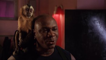 Movie still from “Striptease” (1996), directed by Andrew Bergman – A man and a monkey in a dark room; Close Up shot, Low angle