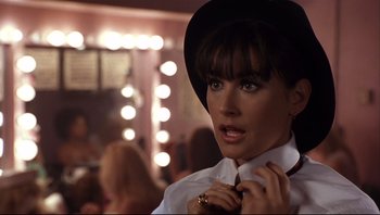 Movie still from “Striptease” (1996), directed by Andrew Bergman – A person wearing a hat and a tie; Close Up shot, Over the shoulder angle