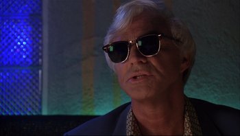 Movie still from “Striptease” (1996), directed by Andrew Bergman – An older man wearing a suit and sunglasses; Close Up shot, Low angle