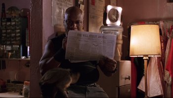 Movie still from “Striptease” (1996), directed by Andrew Bergman – A man reading a newspaper in a room; Close Up shot, Low angle