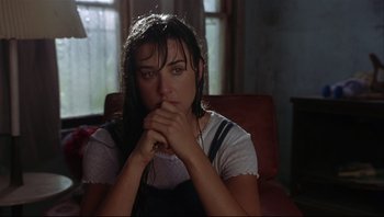 Movie still from “Striptease” (1996), directed by Andrew Bergman – A woman sitting in a chair with her hands clasped together; Close Up shot, Over the shoulder angle