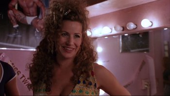 Movie still from “Striptease” (1996), directed by Andrew Bergman – A woman with long curly hair is posing for a picture; Close Up shot, Low angle