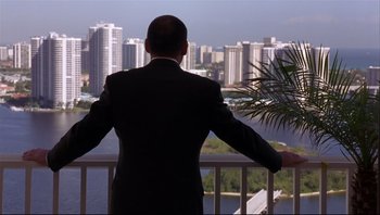 Movie still from “Striptease” (1996), directed by Andrew Bergman – A man in a suit looking out over a city; Wide shot, Over the shoulder angle