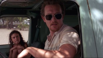 Movie still from “Striptease” (1996), directed by Andrew Bergman – A man in sunglasses sitting in the driver's seat of a car; Close Up shot, Low angle