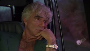 Movie still from “Striptease” (1996), directed by Andrew Bergman – A person wearing a suit and a watch; Close Up shot, Low angle