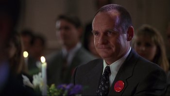 Movie still from “Striptease” (1996), directed by Andrew Bergman – A man in a suit and tie; Close Up shot, Low angle