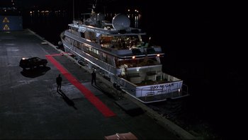 Movie still from “Striptease” (1996), directed by Andrew Bergman – A boat is parked on a dock at night; Extreme Wide shot, High angle