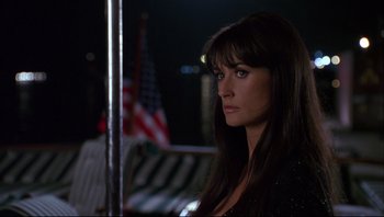 Movie still from “Striptease” (1996), directed by Andrew Bergman – A woman with long black hair is looking at the camera; Close Up shot, Over the shoulder angle
