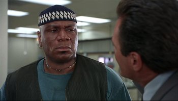 Movie still from “Striptease” (1996), directed by Andrew Bergman – A man in a blue shirt is talking to another man; Close Up shot, Low angle