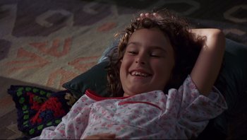Movie still from “Striptease” (1996), directed by Andrew Bergman – A little girl laying on the floor in her pajamas; Close Up shot, High angle