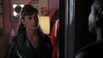 Movie still from “Striptease” (1996), directed by Andrew Bergman – A woman standing in front of a door looking to her left; Close Up shot, Over the shoulder angle