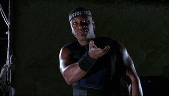 Movie still from “Striptease” (1996), directed by Andrew Bergman – A man in a black shirt and a black headband; Close Up shot, Low angle