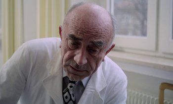 Movie still from “Stroszek” (1977), directed by Werner Herzog – An older man wearing a white lab coat and tie; Close Up shot, Low angle