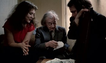 Movie still from “Stroszek” (1977), directed by Werner Herzog – A man sitting at a table with two women; Medium shot, Over the shoulder angle