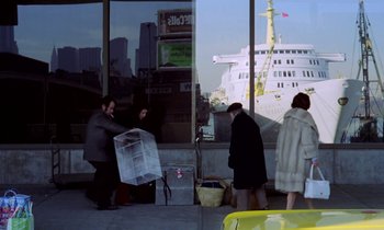 Movie still from “Stroszek” (1977), directed by Werner Herzog – A group of people standing outside of a building; Wide shot, Over the shoulder angle