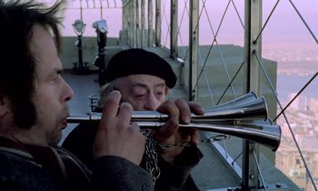 Movie still from “Stroszek” (1977), directed by Werner Herzog – A man is holding a trombone and a chain; Close Up shot, Low angle