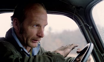 Movie still from “Stroszek” (1977), directed by Werner Herzog – A person driving a car; Close Up shot, Low angle
