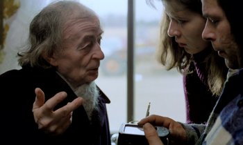 Movie still from “Stroszek” (1977), directed by Werner Herzog – An older man and a young woman are looking at a pen; Close Up shot, Over the shoulder angle