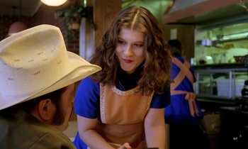 Movie still from “Stroszek” (1977), directed by Werner Herzog – A woman in an apron talking to a man in a cowboy hat; Medium shot, Over the shoulder angle