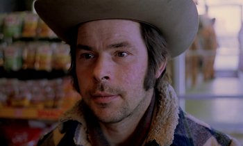 Movie still from “Stroszek” (1977), directed by Werner Herzog – A person wearing a cowboy hat; Close Up shot, Over the shoulder angle