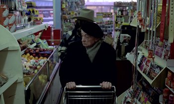 Movie still from “Stroszek” (1977), directed by Werner Herzog – An older woman pushing a shopping cart in a grocery store; Medium shot, High angle
