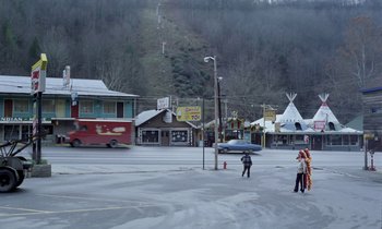 Movie still from “Stroszek” (1977), directed by Werner Herzog – Two people standing on the side of a road; Extreme Wide shot, High angle