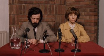 Movie still from “Submarine” (2010), directed by Richard Ayoade – A man and a woman sitting in front of microphones; Medium shot, High angle