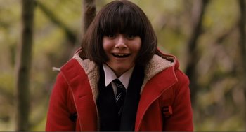 Movie still from “Submarine” (2010), directed by Richard Ayoade – A young woman in a red coat and a tie; Close Up shot, Low angle