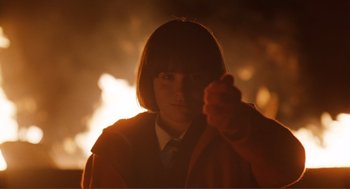 Movie still from “Submarine” (2010), directed by Richard Ayoade – A person in a jacket and tie in front of a fire; Close Up shot, Low angle