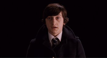 Movie still from “Submarine” (2010), directed by Richard Ayoade – A young man wearing a coat and a tie; Close Up shot, High angle