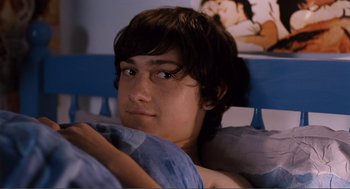 Movie still from “Submarine” (2010), directed by Richard Ayoade – A young man laying in a bed with a blue blanket; Medium shot, High angle