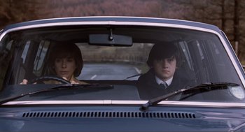Movie still from “Submarine” (2010), directed by Richard Ayoade – A man and a woman sitting in the back seat of a car; Medium shot, Low angle