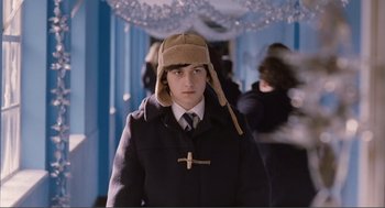 Movie still from “Submarine” (2010), directed by Richard Ayoade – A young man wearing a coat and a hat; Medium shot, Over the shoulder angle