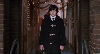 Movie still from “Submarine” (2010), directed by Richard Ayoade – A young man in a black coat and a white tie; Medium shot, High angle