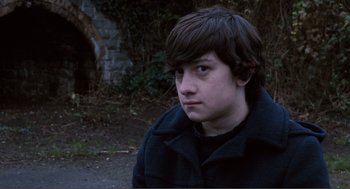 Movie still from “Submarine” (2010), directed by Richard Ayoade – A young man in a black jacket is looking at the camera; Close Up shot, High angle