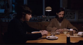 Movie still from “Submarine” (2010), directed by Richard Ayoade – Two men sitting at a table with plates of food; Medium shot, Over the shoulder angle
