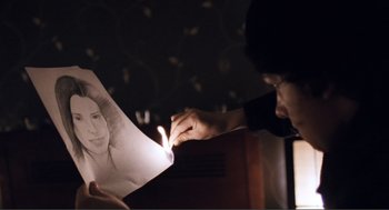 Movie still from “Submarine” (2010), directed by Richard Ayoade – A person is holding a drawing of a woman; Extreme Close Up shot, Over the shoulder angle
