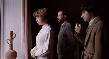 Movie still from “Submarine” (2010), directed by Richard Ayoade – A man and a woman standing next to each other holding drinks; Medium shot, Over the shoulder angle