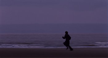 Movie still from “Submarine” (2010), directed by Richard Ayoade – A person running on the beach at night; Extreme Wide shot, Low angle