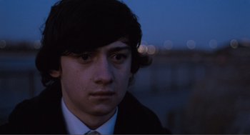 Movie still from “Submarine” (2010), directed by Richard Ayoade – A young man in a white shirt and a black tie; Close Up shot, High angle