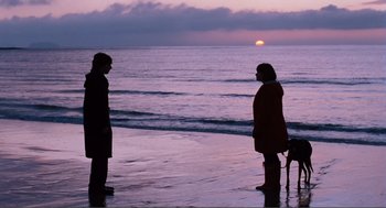 Movie still from “Submarine” (2010), directed by Richard Ayoade – Two people standing on the beach at sunset; Wide shot, Over the shoulder angle