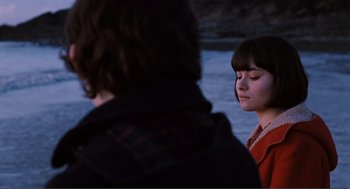 Movie still from “Submarine” (2010), directed by Richard Ayoade – Two people standing next to a body of water; Close Up shot, Over the shoulder angle