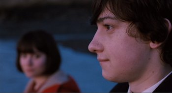 Movie still from “Submarine” (2010), directed by Richard Ayoade – A person's face with a blurry background; Close Up shot, Over the shoulder angle